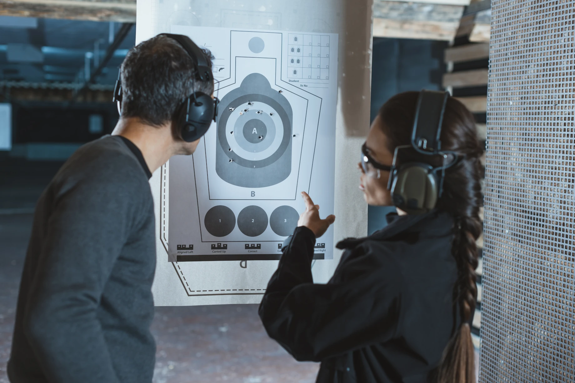 shooting-instructor-pointing-on-used-target-in-sho-2024-11-18-00-14-48-utc